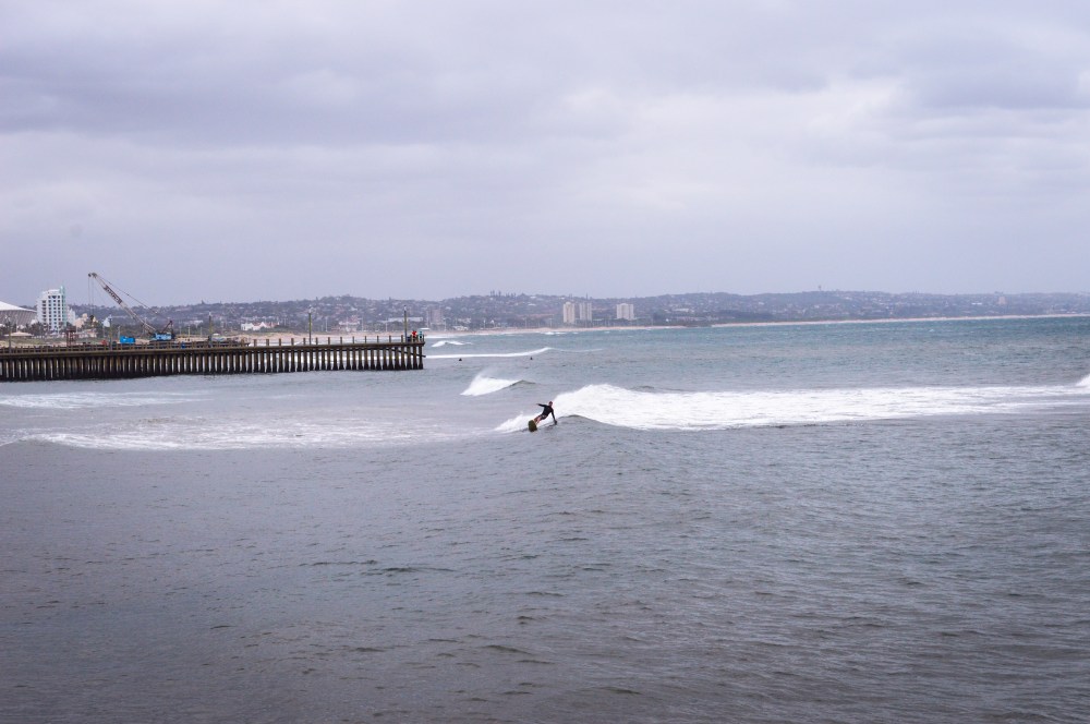 Surfer catching a wave on the beach in Durban 2015